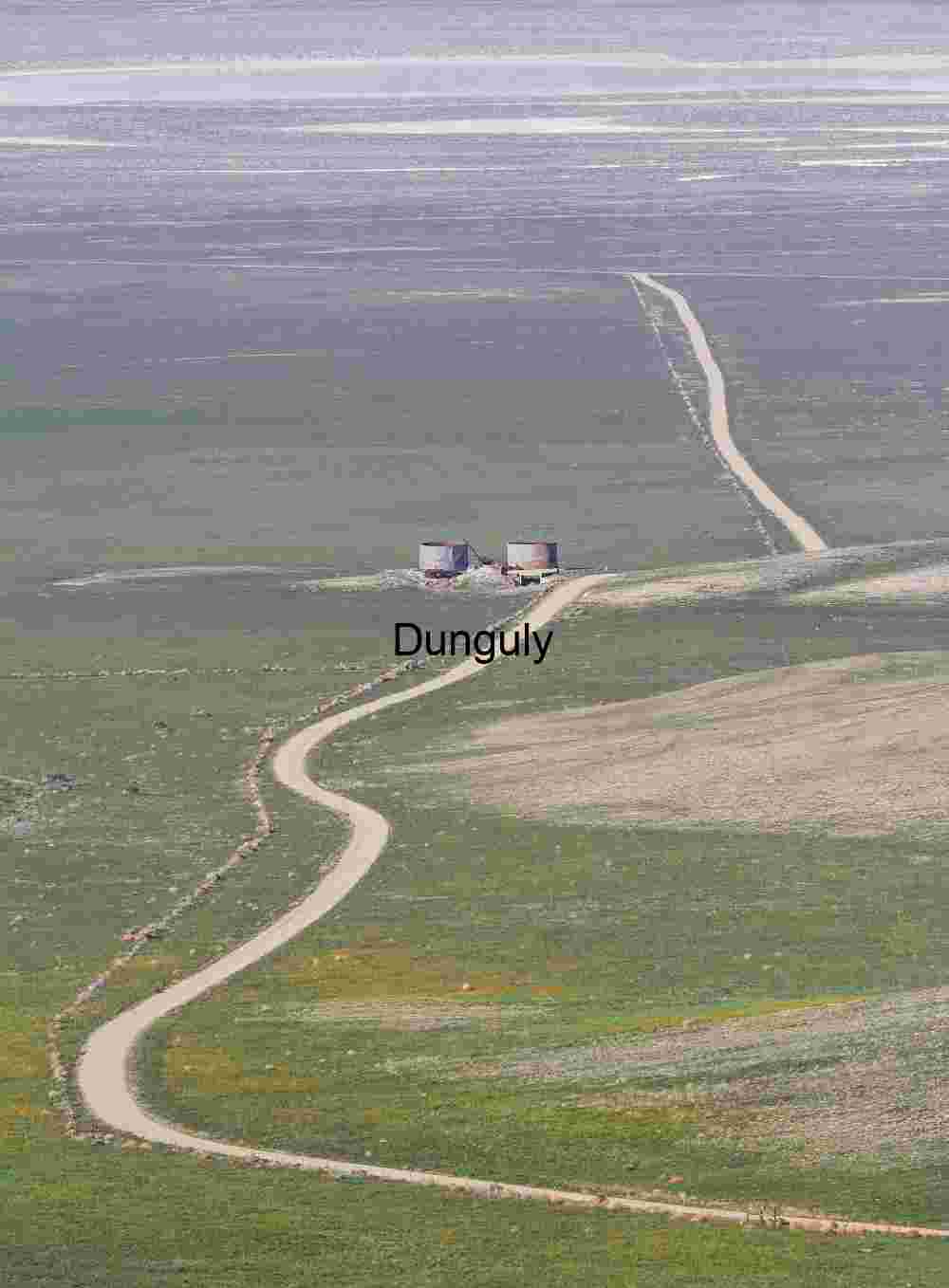 Road descending to Carrizo Plain Silos in Solitude: Winding Road Through Transitional Plains