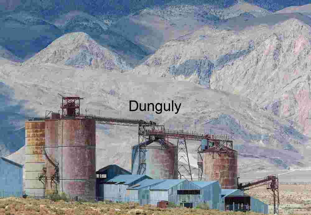 Abandoned processing plant alongside Owens Lake Rust‑Colored Industrial Silos in Mountainous Desert Landscape