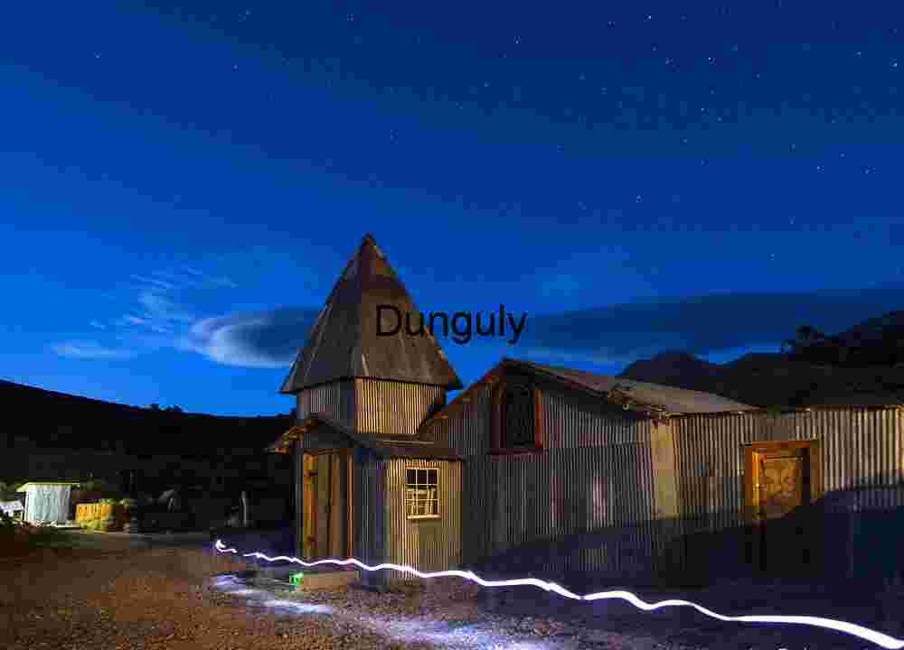 Light trails to the outhouse around the church, Cerro Gordo ghost town Rustic Ghost Town Under Starry Night Sky with Light Trail – Historic Mining Settlement Architecture
