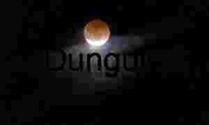 Blood Moon Eclipse Framed by Illuminated Night Clouds