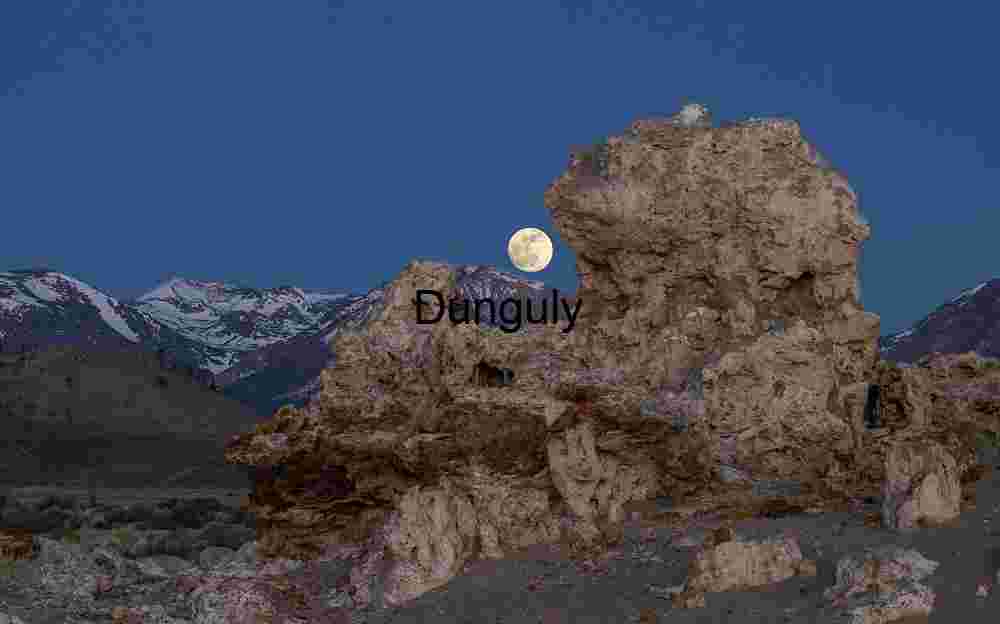 Setting moon cradled in tufa tower; Mono Lake Moonrise Over Stone: Alpine Silence Beneath Lunar Light