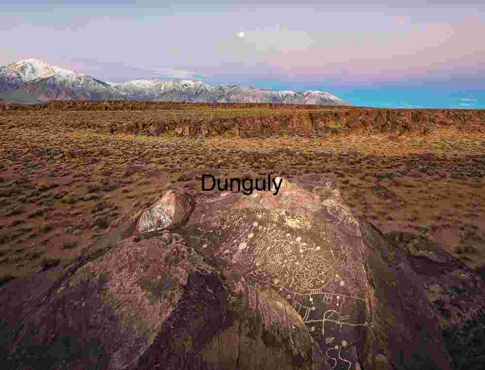 Sky Rock petroglyph with Earth shadow and setting full moon Twilight Petroglyphs: Ancient Symbols on Desert Stone Beneath Moonlit Peaks