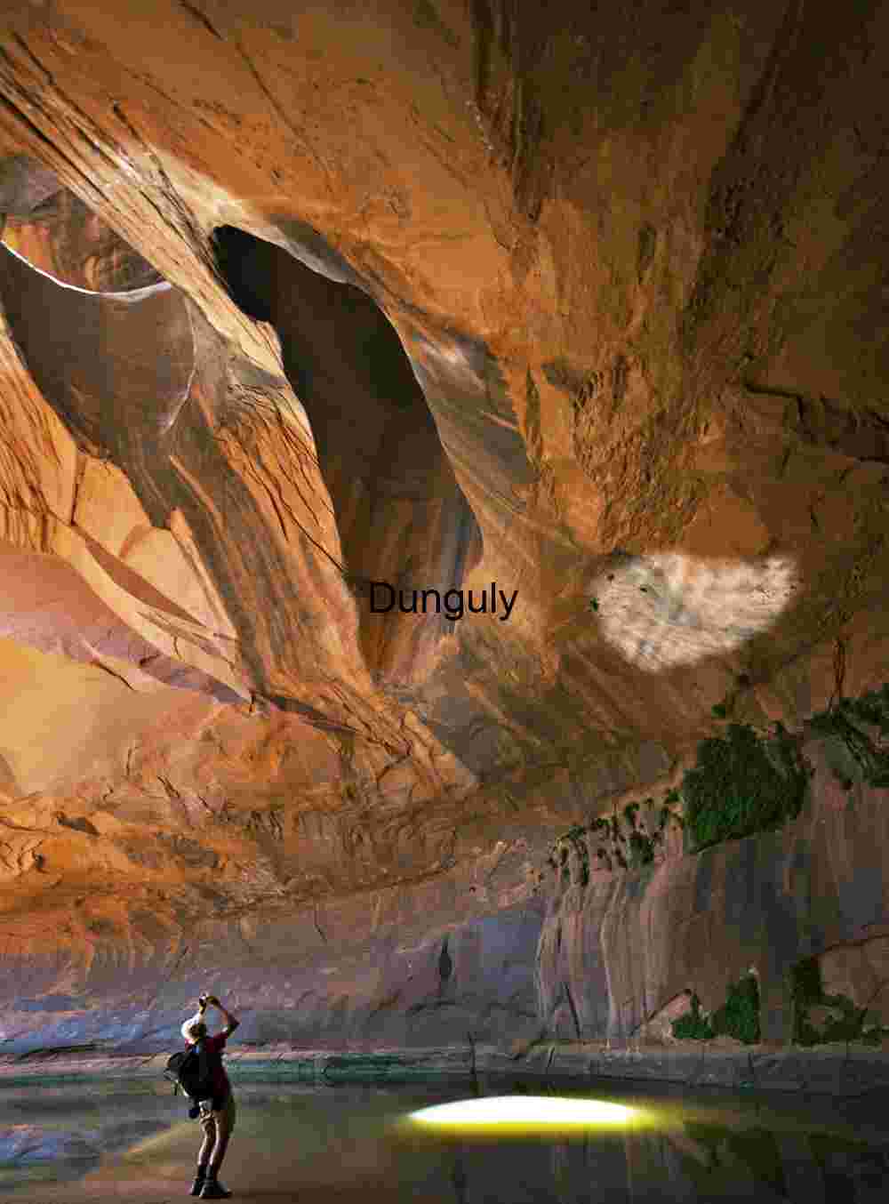 Photographer worshipping in the Golden Cathedral, Neon Canyon, Escalante, Grand Staircase N.M., Utah Golden Cathedral Sunbeam | Photographer in Utah Slot Canyon