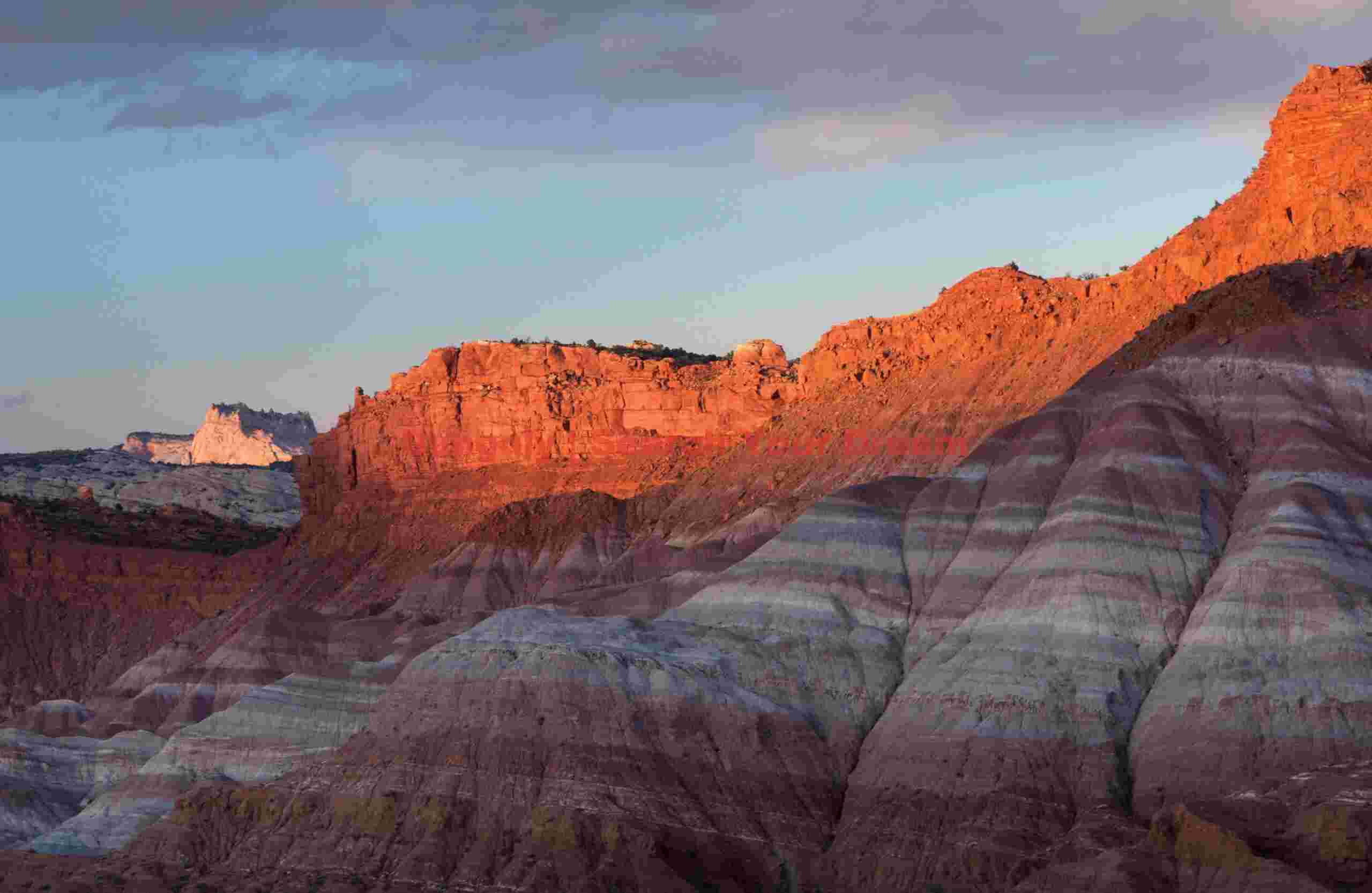 Last light on cliffs above the badlands; Old Pareah Townsite, Utah Golden Sunset Light Bathes Ancient Cliffs