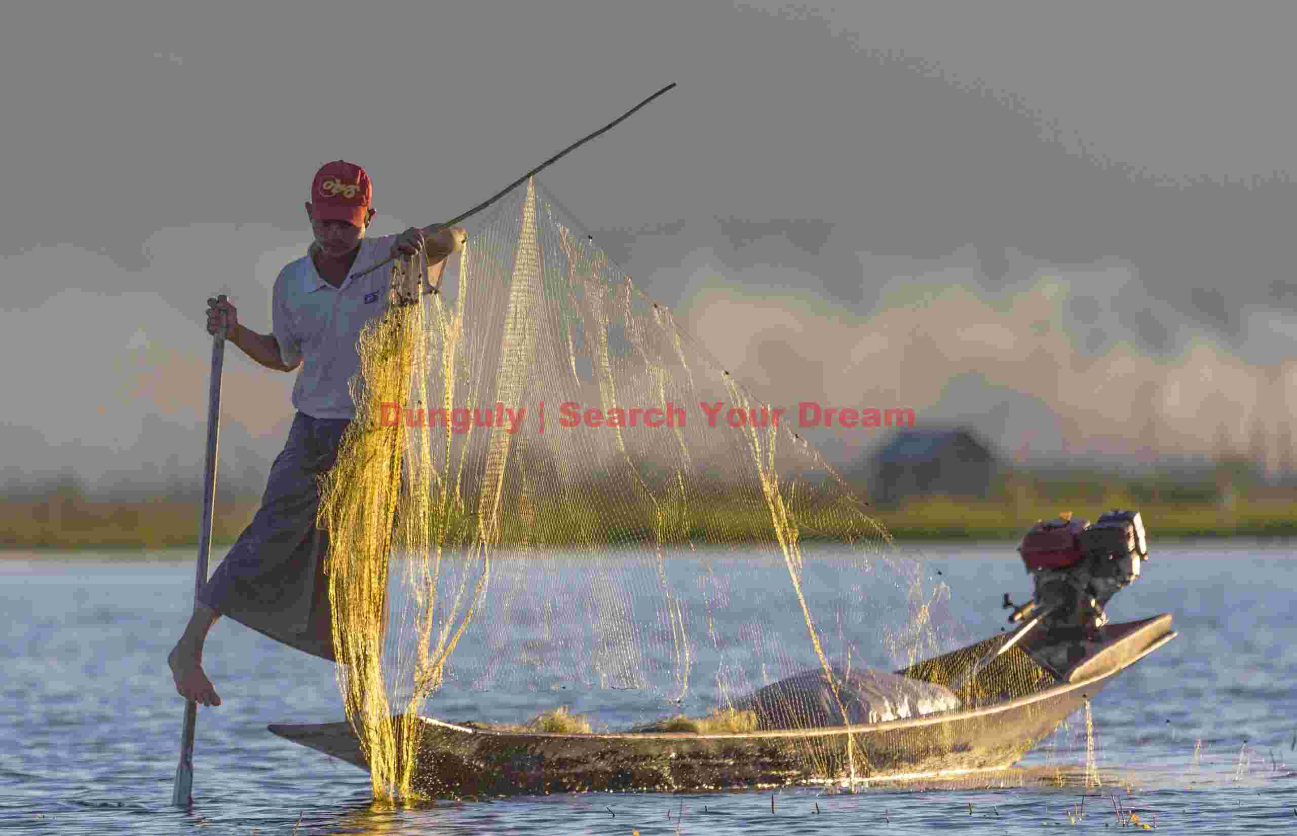 Leg-rowing fisherman with backlit net; Inle Lake, Burma Leg-rowing fisherman with backlit net