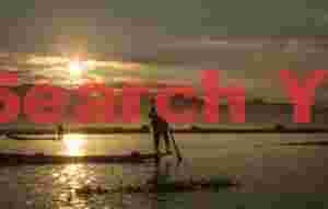Leg-rowing fishermen at sunset