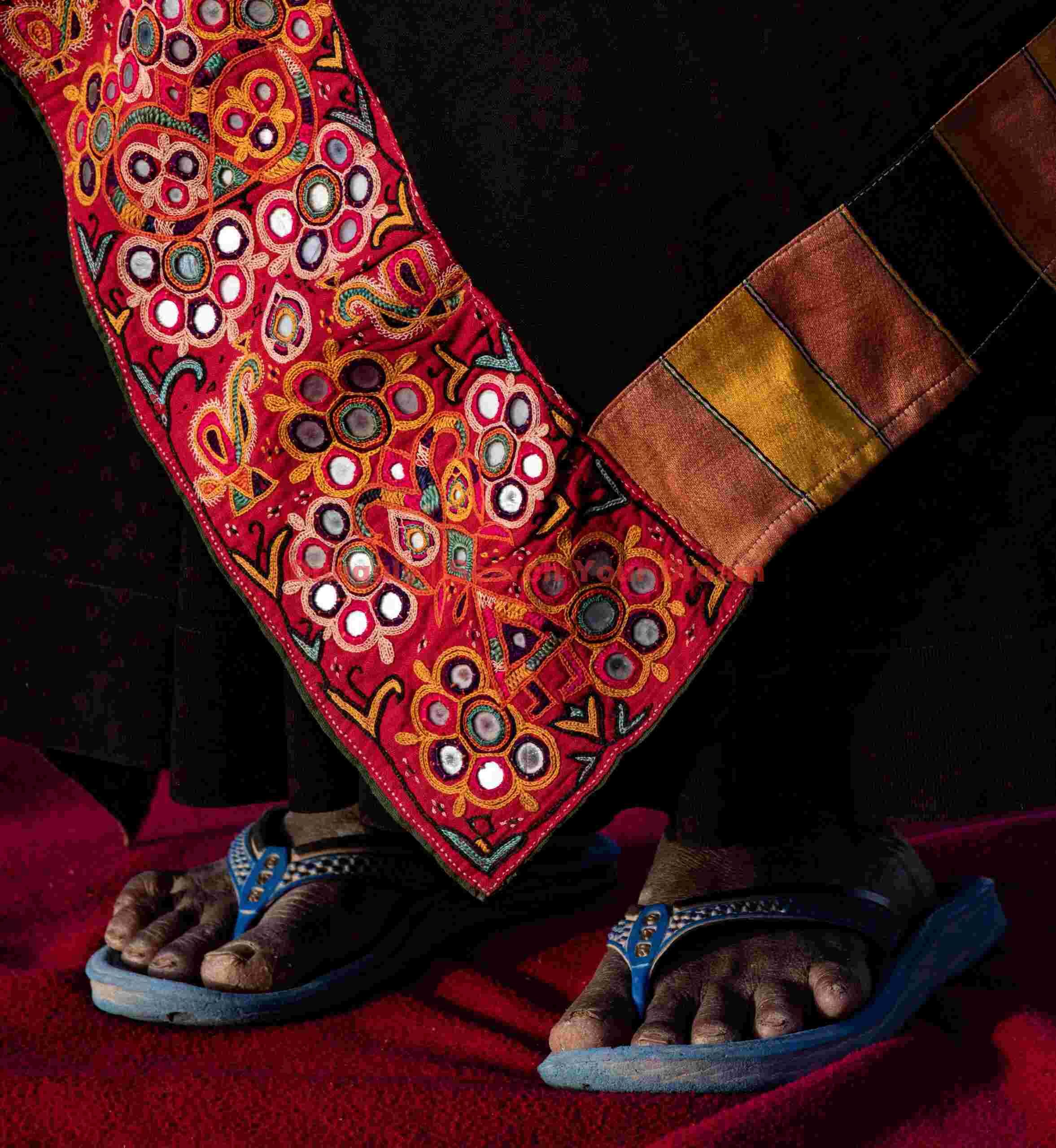 Red embroidery at foot level; Ahir tribe, Rann of Kutch, India Red embroidery at foot level
