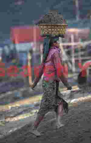 Woman carrying sand basket on head