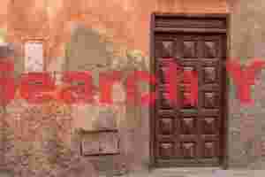 Brown door in faded orange wall