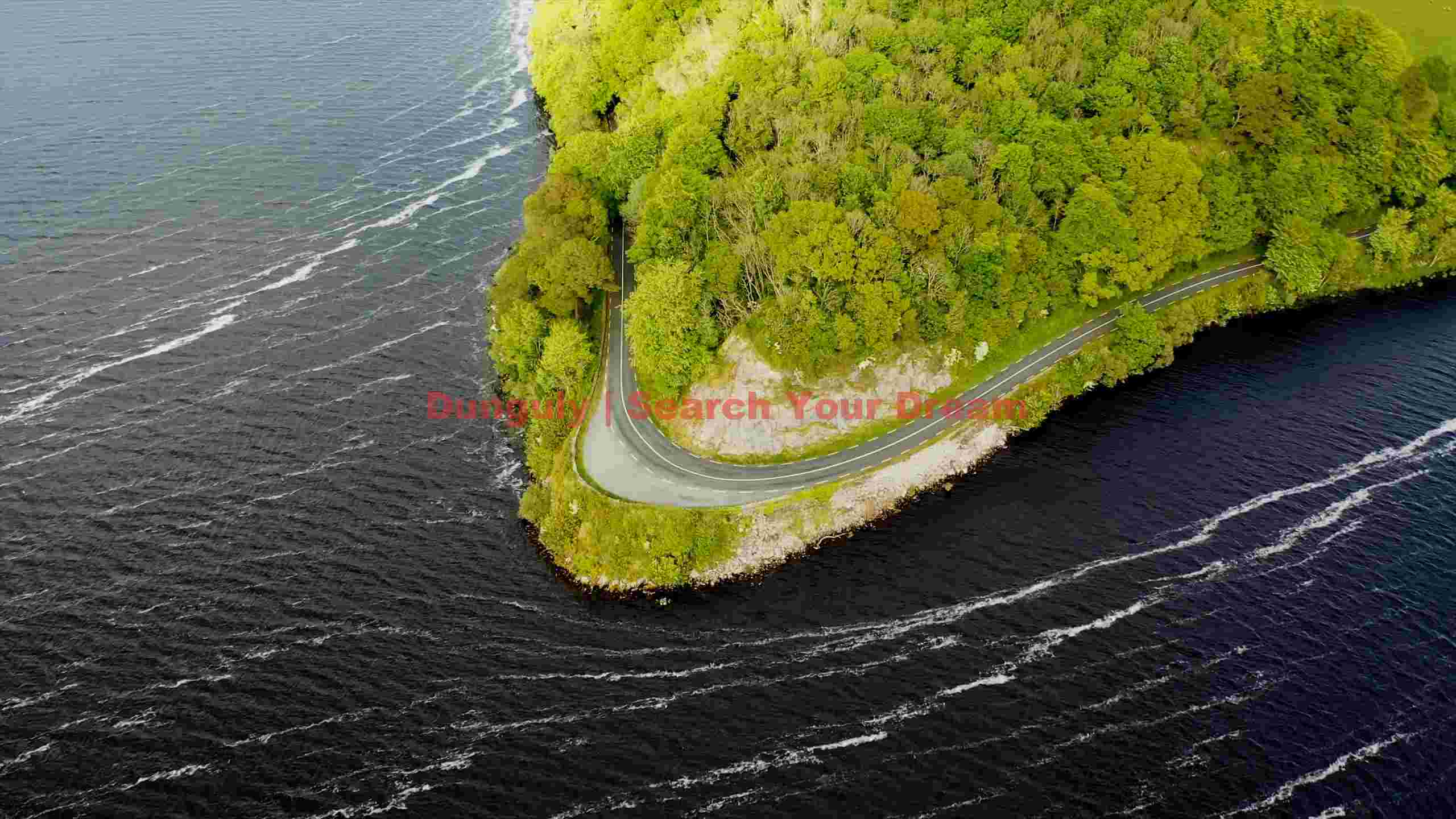 aerial view of scenic coastal road winding through lush forest aerial view of scenic coastal road winding through lush forest