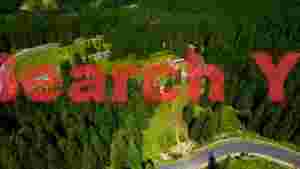 aerial view of serpentine mountain road through dense forest