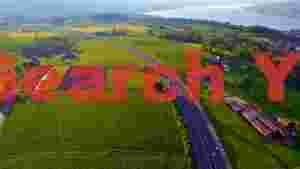 At Home golden hour aerial highway through lush countryside and lake