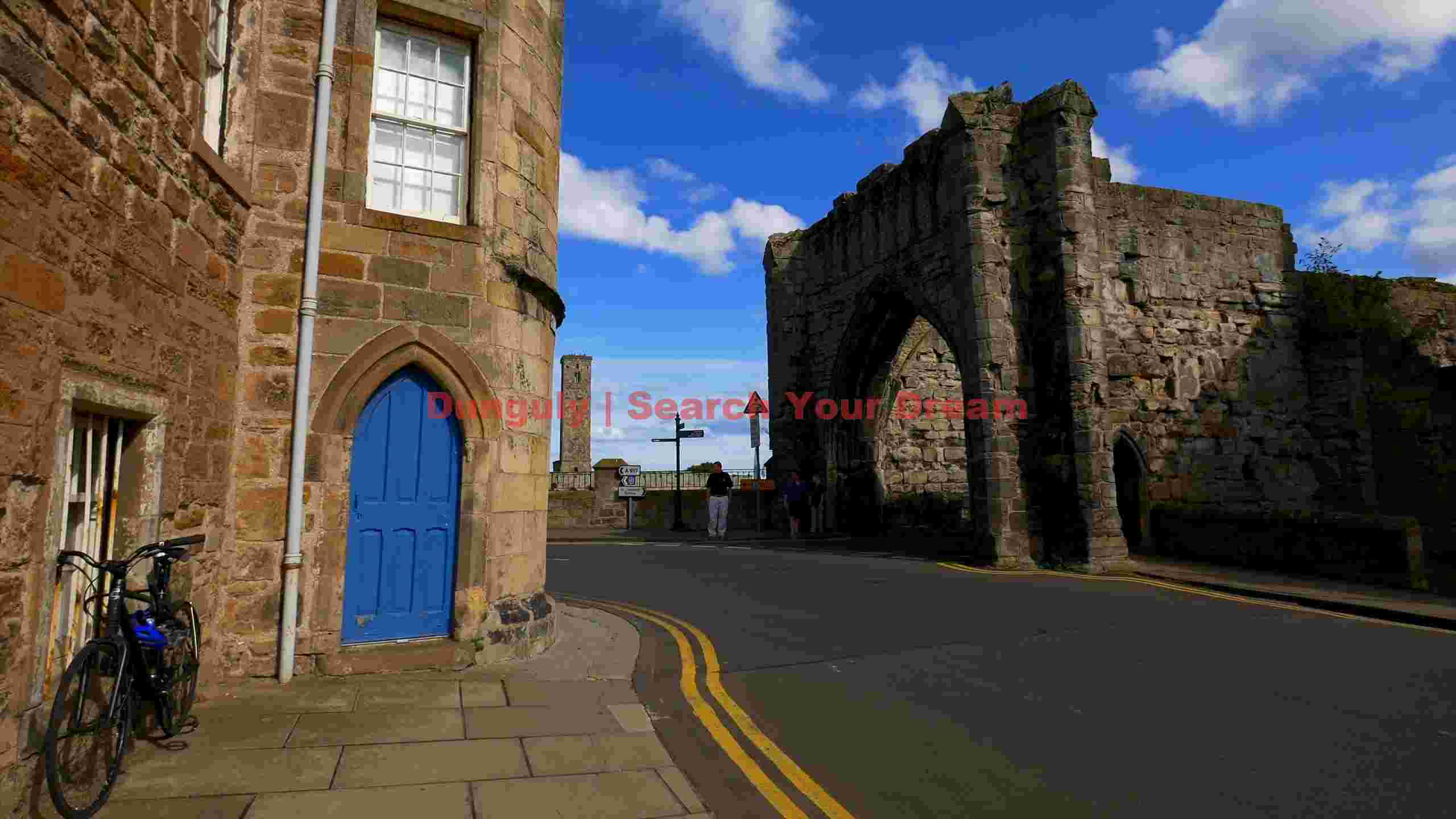 historic st andrews street with ancient arch and blue door historic st andrews street with ancient arch and blue door