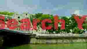 At Home historic white bridge over lush green river