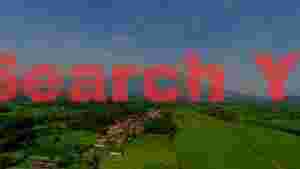 majestic volcano overlooking serene village and rice fields