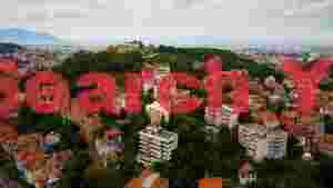 panoramic cityscape amidst green hills