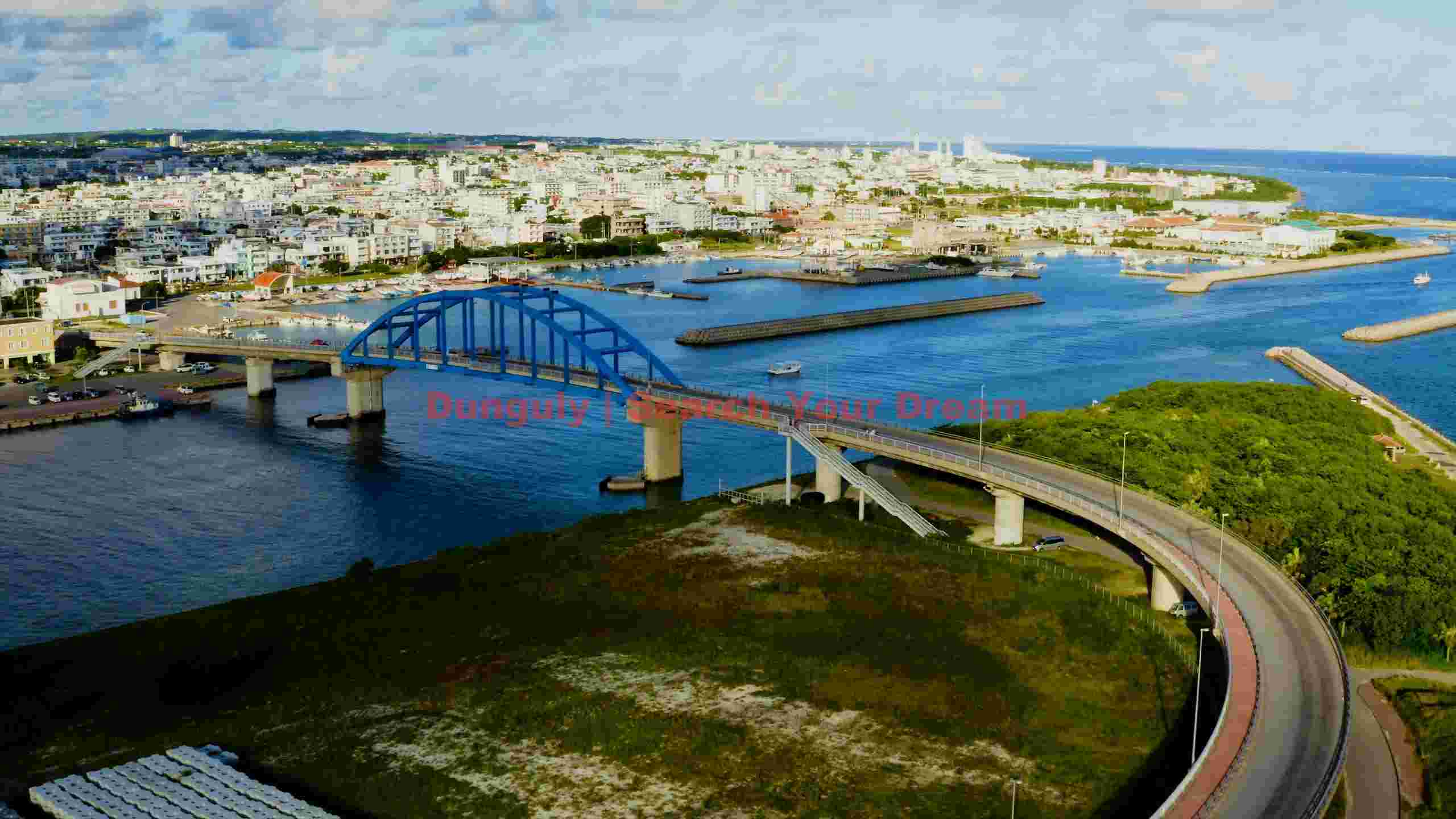 scenic aerial view of okinawas coastal town and blue bridge scenic aerial view of okinawas coastal town and blue bridge