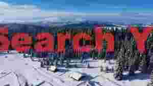 snowy mountain forest with cozy winter cabins