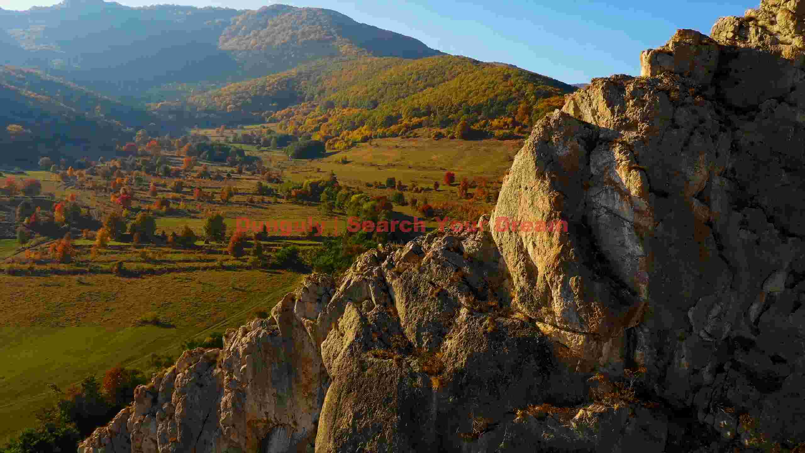 sunlit autumn valley and rocky cliffs sunlit autumn valley and rocky cliffs