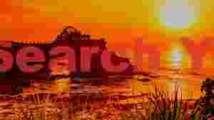sunset glow over coastal temple and sea arch
