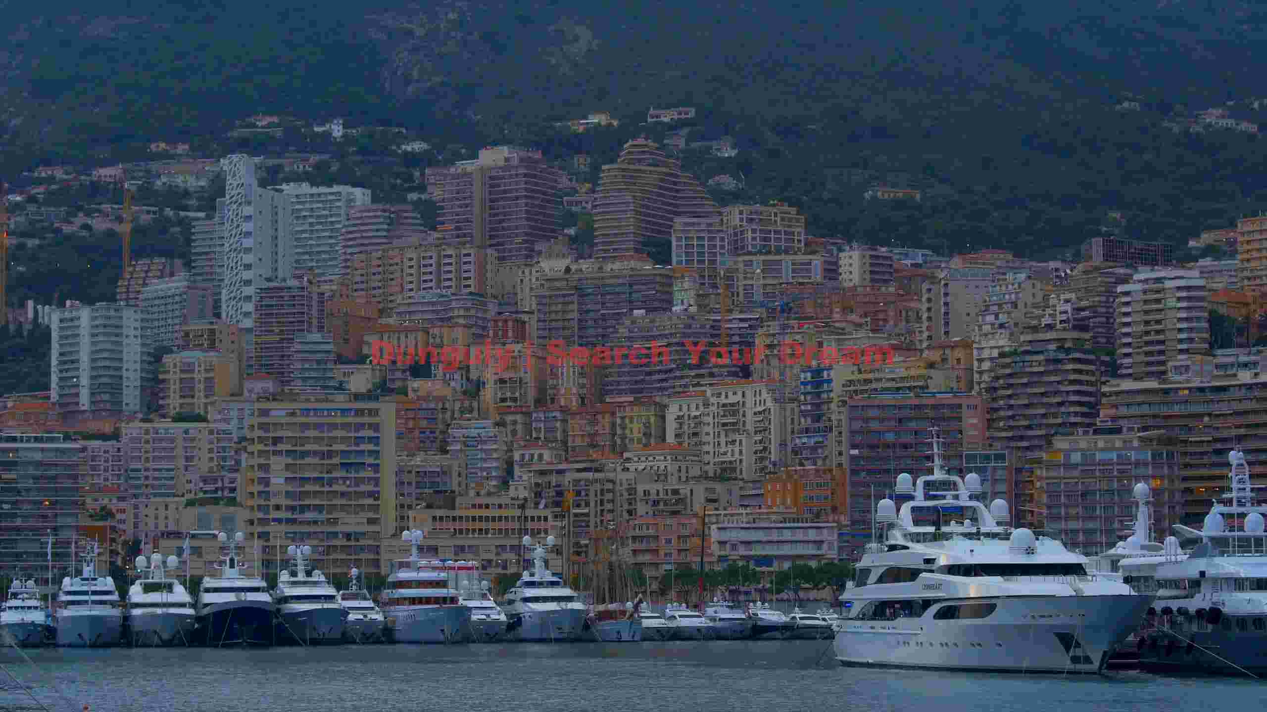 twilight over monaco luxury yachts and hillside cityscape twilight over monaco luxury yachts and hillside cityscape