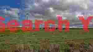 vast wind farm on a green hillside under a dynamic sky