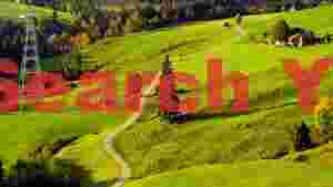 At Home vibrant green alpine valley with winding road and cable car