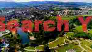 At Home vibrant riverside town and green valleys aerial view