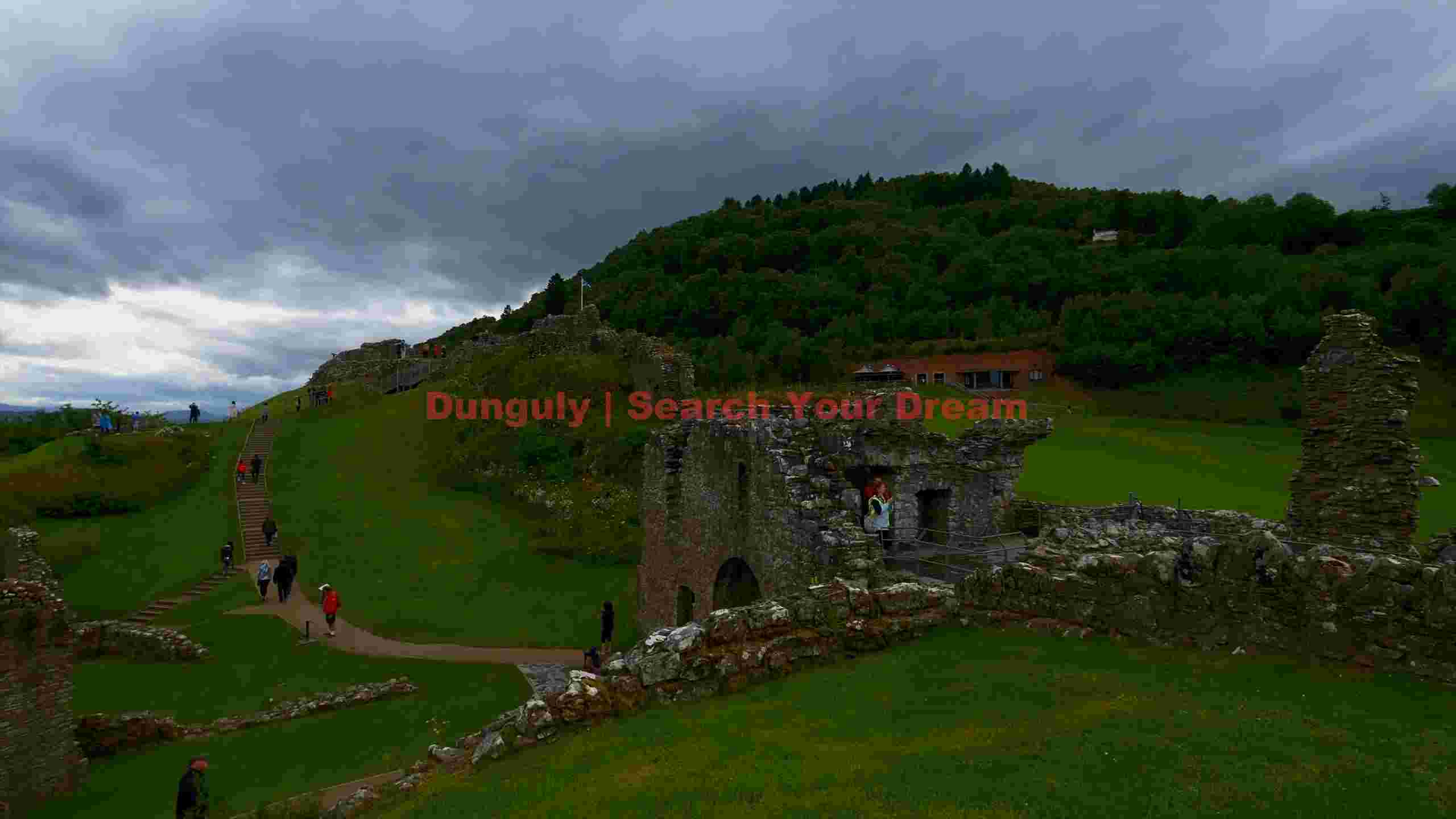 visitors exploring historic scottish castle ruins visitors exploring historic scottish castle ruins