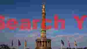 golden victory column in berlin with flags
