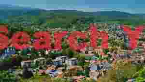 panoramic view of a european town nestled in lush green hills