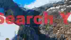 snowy alpine valley with forest and bridge